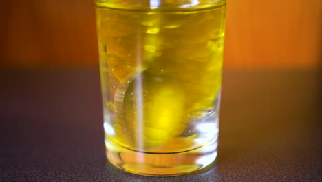 Nahaufnahme-Von-Öl-Und-Wasser-In-Einem-Glas,-Das-Mit-Einem-Löffel-Gerührt-Wird