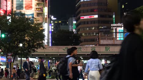 Autos-Und-Tausende-Von-Menschen-Laufen-über-Den-Berühmten-Shibuya-Kreuzung-In-Tokio,-Japan