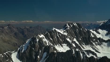 Cámara-Lenta:-Montañas-Rocosas-Cubiertas-De-Nieve-En-El-Parque-Nacional-De-Aoraki-Mountain-Cook,-Alpes-Del-Sur,-Nueva-Zelanda-Desde-Un-Vuelo-Panorámico-En-Avión-Con-El-Lago-Glaciar-Pukaki-En-El-Fondo