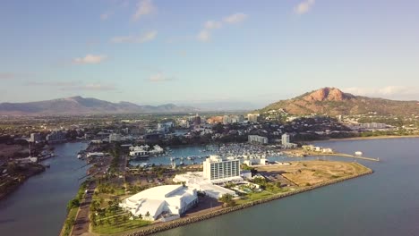 Drone-over-ocean-moving-slowly-toward-Townsville-harbour-and-city-on-a-sunny-morning