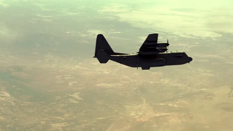 Militärtransportflugzeug-Lockheed-C-130-Hercules,-Das-Von-Links-Nach-Rechts-über-Einer-Wüstenlandschaft-Fliegt