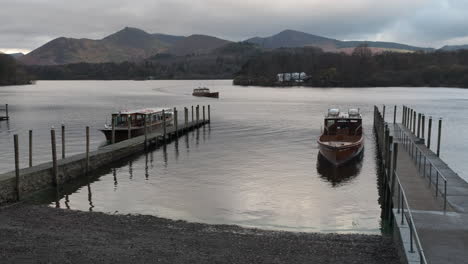 Motor-powered-passenger-boats-on-a-dark-and-gloomy-Derwent-Water,-Keswick-in-the-English-Lake-District,-UK
