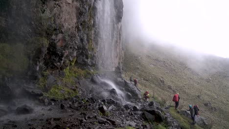 People-walking-on-the-fog-near-a-waterfall-in-the-beautiful-iztaccihuatl-volcano-in-Mexico-in-a-trek-at-about-4,400-meters-above-sea-level