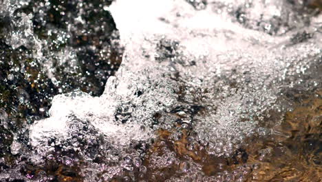 Burbujas-De-Agua-Emergen-De-Un-Arroyo-En-La-Base-De-Una-Cascada-Disparada-En-Cámara-Lenta