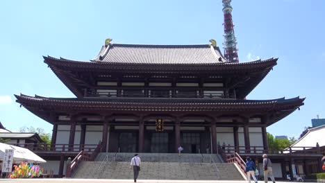 Zojo-ji-Temple,-Tokyo-Tower-and-people-walking-to-the-Zojo-ji-Temple