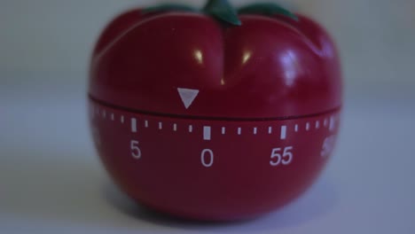 Closeup-of-a-cooking-timer-in-the-shape-of-a-tomato-ticking-until-zero