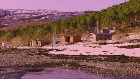 Small-fishermans-huts-at-beach-near-village-in-northern-Norway-coastal-area