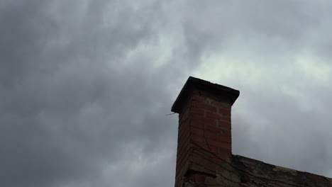 Smoke-rising-from-an-old-brick-chimney-in-strong-wind