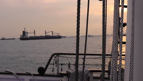 Navegando-El-Puerto-De-Singapur-Al-Atardecer-En-Un-Hermoso-Cielo-Rojo-Por-La-Noche