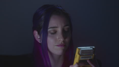 Young-woman-playing-videogames-on-her-portable-device