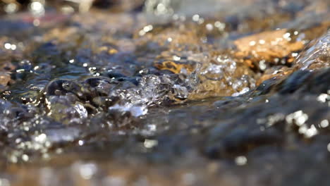 Slow-motion-tight-shot-of-beautiful-sparking-water-flowing-down-stream
