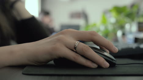 Close-up-shot-as-a-female-hand-with-wedding-ring-using-a-mouse-in-the-office