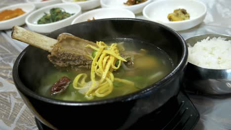 Dampfend-Heiße-Koreanische-Rinderknochensuppe-In-Einer-Steinschüssel