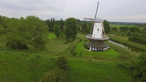 Aerial-shot-of-the-historical-town-of-Veere,-with-an-old-windmill-in-frame