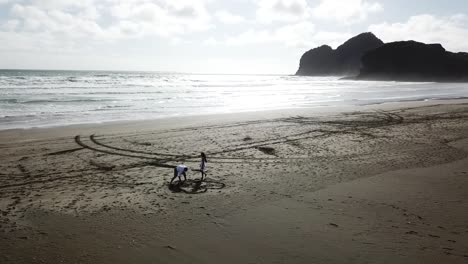 Aerial-shot-of-lovers-drawing-hear-and-names-on-the-beach