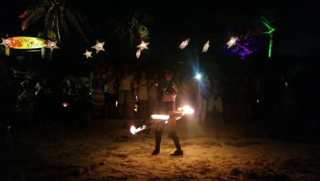 Female-variety-artist-performing-fire-show-on-the-beach-in-front-of-crowd