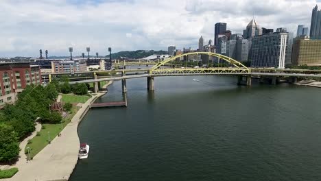Luftschnellboot-Rast-Den-Allegheny-River-Unter-Der-Fort-Duquesne-Brücke-Hinunter-In-Richtung-Der-Skyline-Der-Stadt-Pittsburgh,-Pennsylvania.-Konzept:-Stadt,-Stadtbild,-Felder,-Drohne,-Wasserfahrzeug