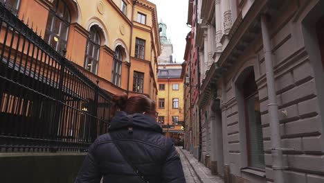 Woman-walking-through-a-narrow-street-in-Stockholm