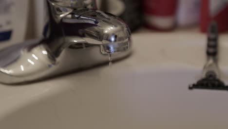 Water-droplets-leaking-from-a-bathroom-faucet