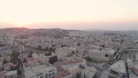 Fly-down-twilight-hour,-red-sunset-over-Jerusalem-city,-aerial-view,-drone