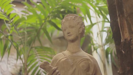 Sculpture-of-an-ancient-goddess-or-nymph-on-a-green-patio-garden