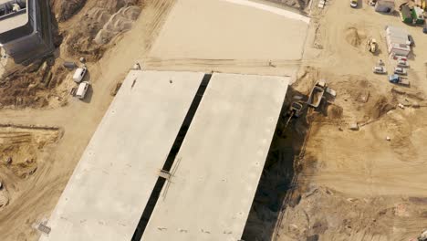 Aerial-footage-of-a-large-scale-highway-construction-site-with-trucks,-excavators-and-loaders-working-on-bridges-and-roads
