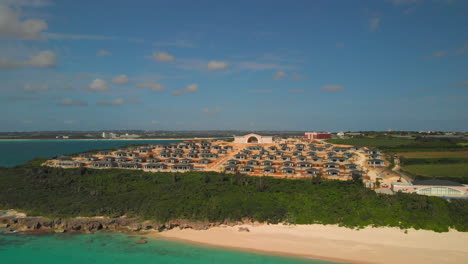 Aufschlussreiche-Aufnahme-Eines-Tropischen-Strandes-Mit-Türkisfarbenem-Wasser-Und-Einer-Luxussiedlung-Im-Hintergrund