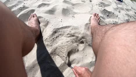 Playing-with-a-stick-in-the-sand-slow-motion-first-person