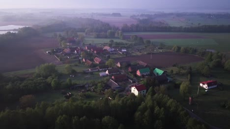 4k-footage-of-a-village-near-lake-surrounded-by-forest-from-birds-eye-perspective