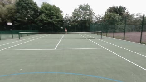 Point-of-view-shot-of-amateur-tennis-player-playing-in-park-with-female-player