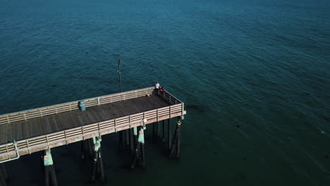 Man-fishing-at-the-end-of-pier-in-the-afternoon