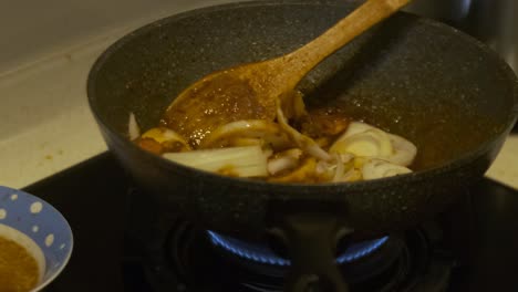 Closeup-of-cooking-Chilli-Prawns-with-Onions-in-a-cooking-pot-on-a-stove