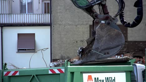 Large-excavator-hand-loading-dirt-and-debris-on-to-a-truck-in-slow-motion