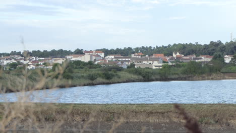 Distant-view-of-the-village-of-Saint-Trojan-les-Bains-with-the-ocean-flood-protection-basin,-Oleron-island,-France