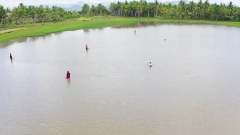 Luftaufnahme-über-Eine-Gruppe-Von-Männern,-Die-Netze-Im-Tropischen-Lagunenwasser-Anpassen