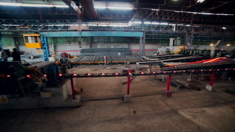 Men-are-working-in-steel-rods-factory,-Hot-steel-roads-in-process,-camera-panning-view