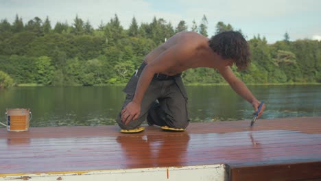 Junger-Mann-Bemalt-Holzdachplanken-Für-Bootskabinen-Mit-Schützender-Außenfarbe