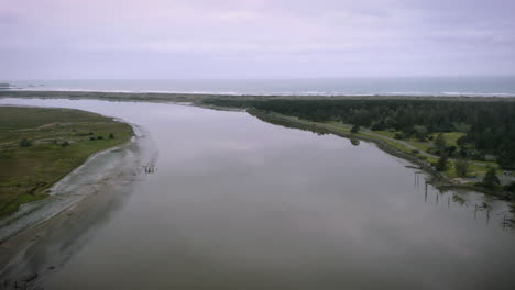 Peaceful-sunrise-footage-of-drone-flying-over-the-Coquille-River-near-Bandon,-Oregon