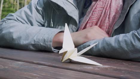 Gerade-Fertiger-Origami-Papierschwan,-Nahaufnahme-Mit-Mädchen-Im-Hintergrund