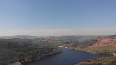Drone-travelling-rising-with-Lady-Bower-Reservoir-in-view-from-Bamford-Edge-in-the-Peak-District-shot-in-4K