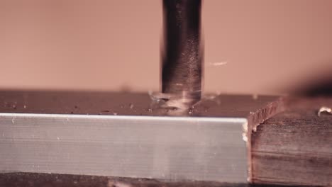 Drilling-aluminium-block-with-very-sharp-drillbit,-metal-scraps-taking-off