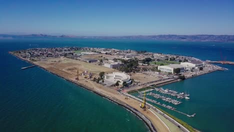 4k-aerial-drone-view-of-treasure-island-san-francisco-bay-area-surrounded-by-turquoise-blue-ocean-sea-water-waves-camera-fly-up
