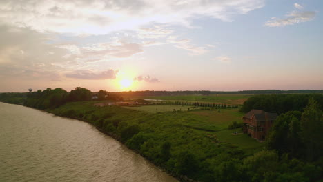 Drohne-Zieht-Sich-Vom-Ufer-Zurück-Und-Sonnenuntergang-über-Dem-Wasser