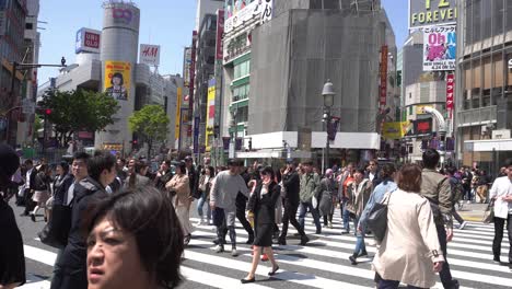 Fußgänger-In-Eile-Auf-Der-Berühmten-Shibuya-Kreuzung-In-Tokio,-Japan
