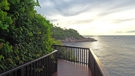 Beautiful-view-of-the-seaside-wooden-walkway-with-a-metal-railing