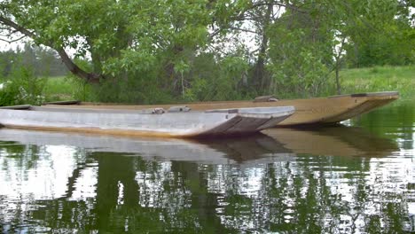 Traditionelle-Holzboote-Namens-Drevak-Auf-Dem-Cerknica-See-Unter-Einem-Baum