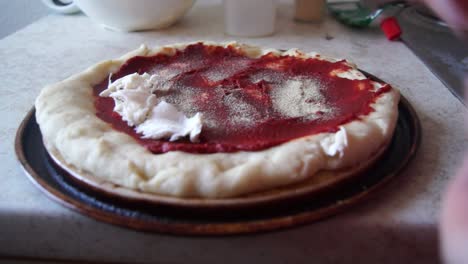 Putting-mozzarella-on-a-prebaked-pizza-base