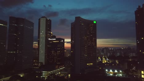 Aerial-lateral-rising-drone-shot-of-Singapore-skyline-during-sunset