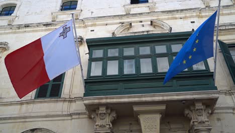 Malta-Und-Die-EU-Flagge-Wehen-Im-Wind-Vor-Einem-Traditionellen-Maltesischen-Balkon-Im-Außenministerium-In-Valletta