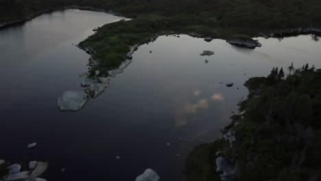 Drone-Volando-Sobre-La-Reflexión-En-El-Lago-Con-Nubes-Y-Panoramización-Para-Mostrar-La-Puesta-De-Sol-Sobre-El-Océano-Atlántico-En-Nueva-Escocia-En-Canadá